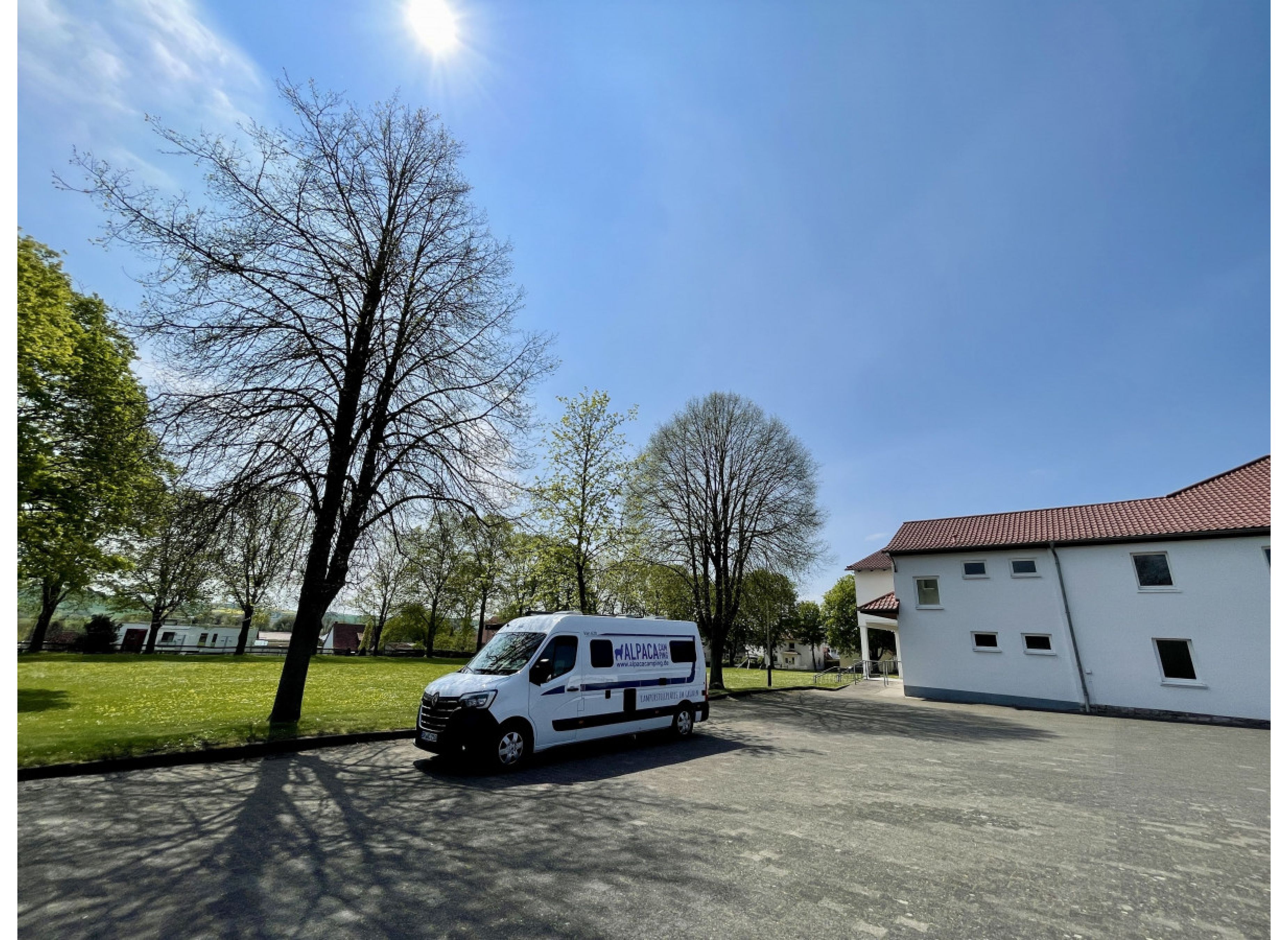 Stellplatz auf einem Hallenvorplatz neben einer grünen Wiese — Photo 2