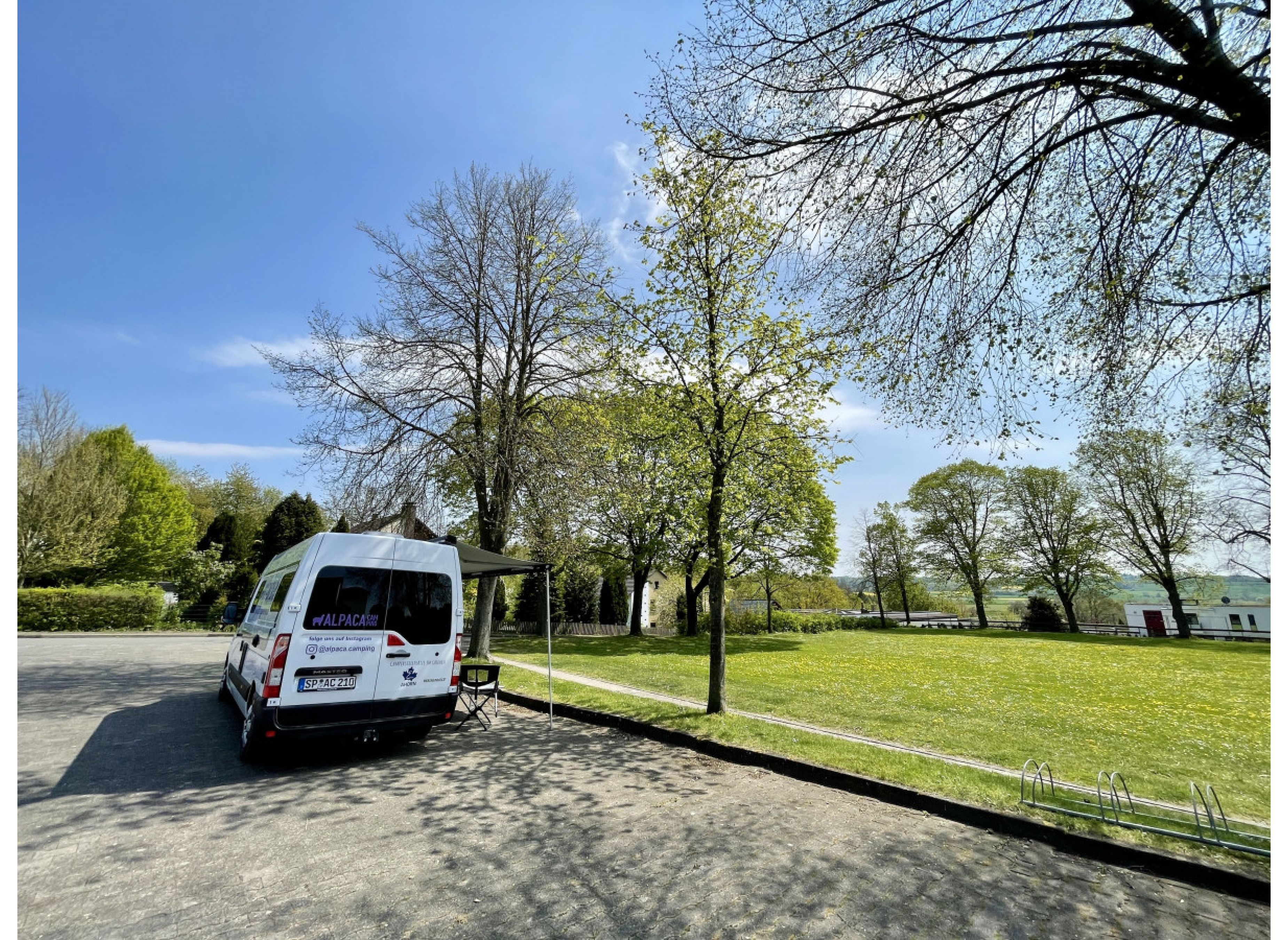 Stellplatz auf einem Hallenvorplatz neben einer grünen Wiese — Photo 3